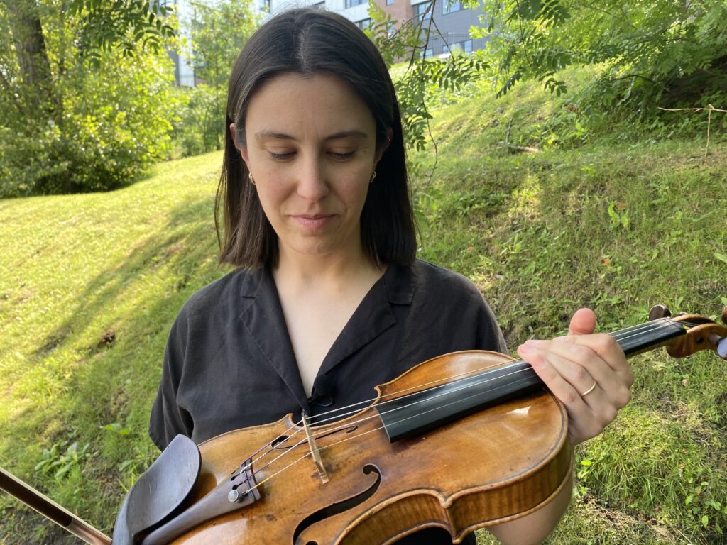 Une femme tient un violon